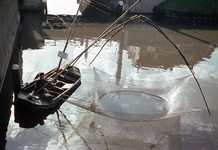 849501 Afbeelding van visser P. Arbeider met zijn vissersboot bij de Tolsteegbrug te Utrecht.